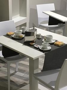 エルコラーノにあるb&b hotel pizzeria la romanticaのテーブル(カップ、皿付)