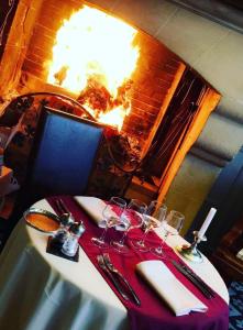a table with wine glasses on a table with a fireplace at Relais Saint Louis, Logis in Bellême