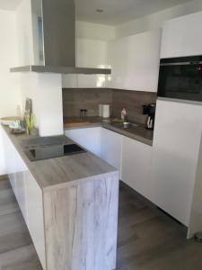a kitchen with white cabinets and a wooden counter top at Apartamenty Platinum in Łukęcin
