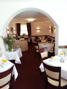 a dining room with white tables and chairs at Haus Sparkuhl Hotel Garni in Hannover