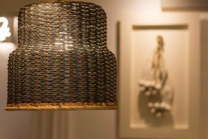 a wicker chandelier hanging from a wall next to a door at Adua19 Apartment in Fasano