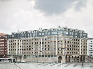 un gran edificio de oficinas con muchas ventanas en Residencial Playa Poniente, en Gijón