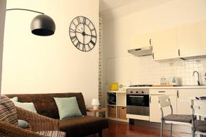 a living room with a couch and a clock on the wall at Apartment - Laterano 85 in Rome