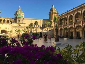 a large building with purple flowers in front of it at casa vacanze Sciaraba in Mazara del Vallo