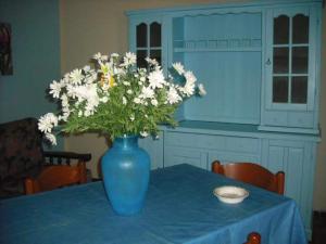 un jarrón azul con flores blancas en una mesa en casa vacanze Sciaraba, en Mazara del Vallo