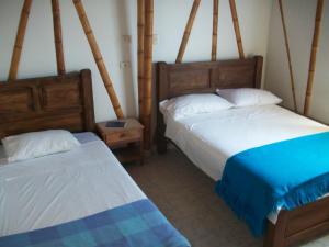 a bedroom with two beds and two night stands at Hotel El Ganadero in El Total