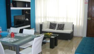 a living room with a table and a couch at apartamentos Los cedros in Lima