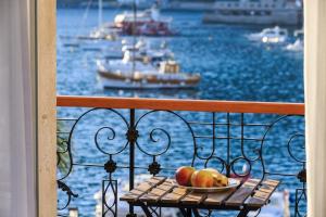 a bowl of fruit on a table on a balcony with boats at Seafront rooms Koluna in Komiža +32 photos