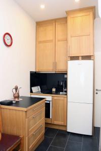 a kitchen with wooden cabinets and a white refrigerator at Epicentar in Sarajevo