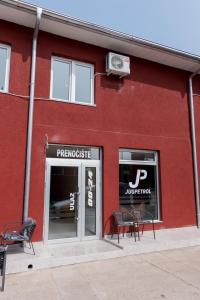 a red building with tables and chairs in front of it at Prenoćište HRAST in Paraćin