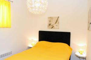 a bedroom with a yellow bed and a chandelier at Epicentar in Sarajevo
