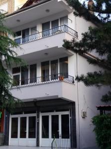 Edificio blanco con ventanas y balcón en LEVI Apartment, en Pogradec