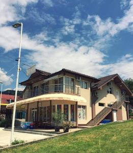 a large house with a staircase in front of it at Guest House Konak Iris in Predejane