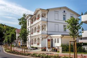 - un bâtiment blanc avec des finitions blanches dans une rue dans l'établissement Hotel Garni Getreuer Eckart, à Binz