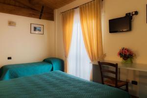 Villa Montotto في Monterubbiano: غرفة نوم بسرير ونافذة بها تلفزيون