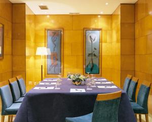 
a dining room table with chairs and a large mirror at Hotel Villacarlos in Valencia
