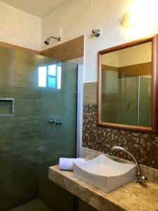 a bathroom with a sink and a shower at Pousada Caminho do Sol in Arraial do Cabo