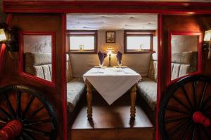 um pequeno quarto com uma mesa e duas janelas em Cairndow Stagecoach Inn em Cairndow