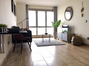 - un salon avec une table et une grande fenêtre dans l'établissement Residencial Playa Poniente, à Gijón
