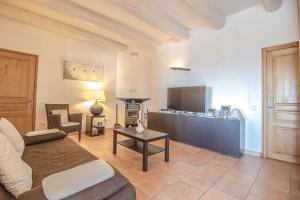 een woonkamer met een bank en een tv bij Les Clèdes du Mazel in Banne