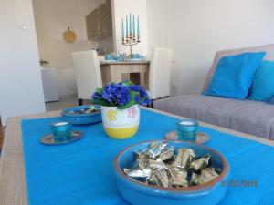 een tafel met drie kommen eten op een blauwe tafeldoek bij Apartment Erika in Novi Sad