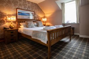 um quarto com uma cama grande e uma janela em Cairndow Stagecoach Inn em Cairndow