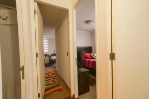 a hallway leading to a living room with a red couch at Apartamento hogareño in Santiago