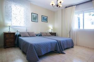 ベナルマデナにあるApartamento Nadales a 100 Metros De La Playaのベッドルーム1室(青い毛布、窓付)
