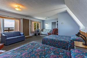 une chambre d'hôtel avec deux lits et un canapé dans l'établissement Auberge de L'Anse, à Rivière-du-Loup