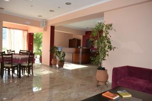 a living room with a purple couch and a dining room at Kalias Hotel in Vasiliki