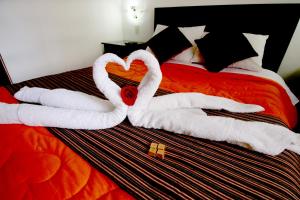 Dos cisnes hechos de toallas en una cama en Hotel Peru Real, en Cusco