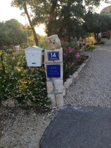 a stone mailbox with a sign for a yard at Apartments Milena in Pinezici