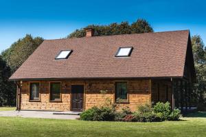 Leitāni的住宿－Lakeside holiday house "Beavers" Bebruciems，一间棕色屋顶的小砖屋