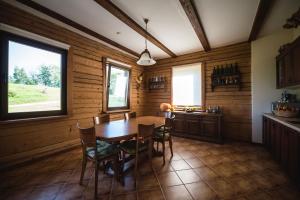 uma cozinha com mesa e cadeiras num quarto em Lakeside holiday house "Beavers" Bebruciems em Leitāni