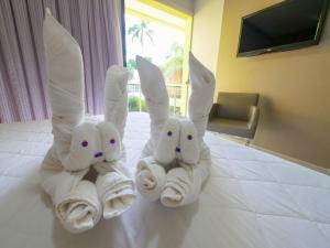 three rolls of towels on a bed in a hotel room at Marruá Hotel in Bonito