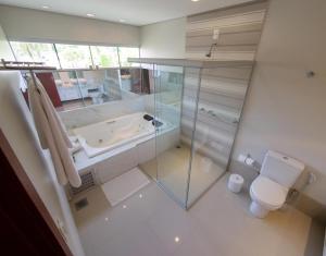 a bathroom with a tub and a toilet and a shower at Marruá Hotel in Bonito