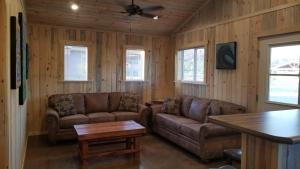 a living room with two couches and a table at Bluff Gardens in Bluff