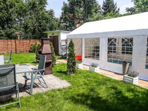 a white tent in a yard with a grill at Apartamenty Pan Tadeusz Ustroń in Ustroń