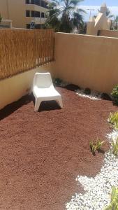 a white toilet sitting in a yard next to a fence at Bungalow Mencey in El Médano