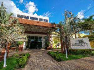 a building with palm trees in front of it at Marruá Hotel in Bonito