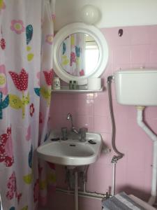 ein Bad mit einem Waschbecken und einem Spiegel in der Unterkunft Hotel Methanion in Methana