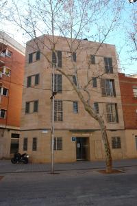 un edificio con un árbol delante de él en Hostal Rambla, en Sant Boi del Llobregat