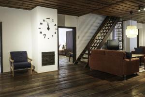 ein Wohnzimmer mit einer Treppe und einer Uhr an der Wand in der Unterkunft Ferienwohnung Moarhofer in Muhr