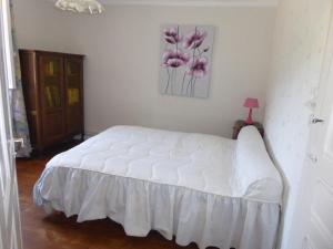 una camera da letto con un letto bianco e fiori rosa sul muro di Au coeur de la campagne - Gite non loins d'Annecy- à 17 min d'Annecy - Tout prêt d'Aix les Bains a Saint-Girod