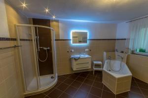 een badkamer met een douche, een bad en een wastafel bij Ferienwohnung "Turmblick" in Rathmannsdorf
