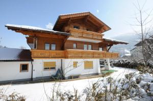 a house with a wooden roof in the snow at Chalet Alice by Schladmingurlaub in Schladming