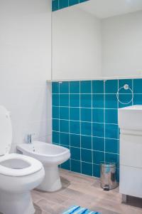 a bathroom with a toilet and a blue tiled wall at Flat in Las Cañitas. in Buenos Aires
