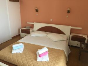 1 dormitorio con 1 cama con toallas en Hotel Methanion, en Metana