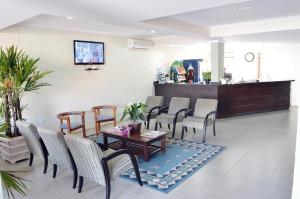 una sala de espera con sillas, una mesa y un mostrador en Hotel Ijuí, en Ijuí