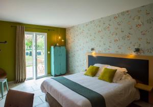 um quarto com uma cama grande e paredes verdes em Auberge Pom'Poire em Azay-le-Rideau